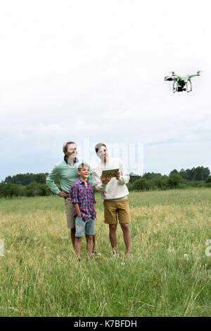 Multi-generation family Playing with drone in field Banque D'Images