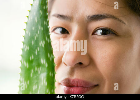 Femme avec des feuilles d'aloe vera Banque D'Images