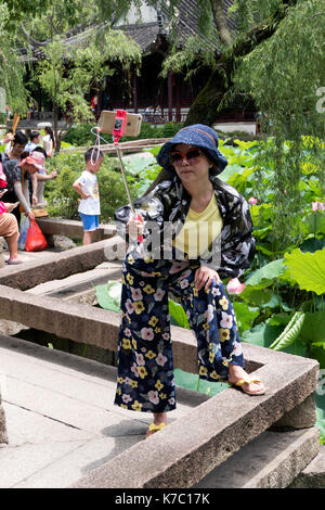 Femme chinoise et touristes dans le jardin de l'humble administrateur à Suzhou, Chine, Asie, site du patrimoine mondial de l'UNESCO Asie Voyages et tourisme. Banque D'Images