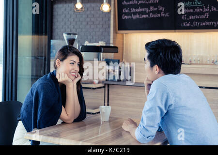 Rencontres dans un café. belle asiatique amant couple sitting in a cafe bénéficiant dans le café et conversation. L'amour et la romance. Banque D'Images