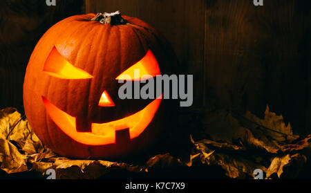 Halloween citrouille et des feuilles sèches sur fond de bois Banque D'Images