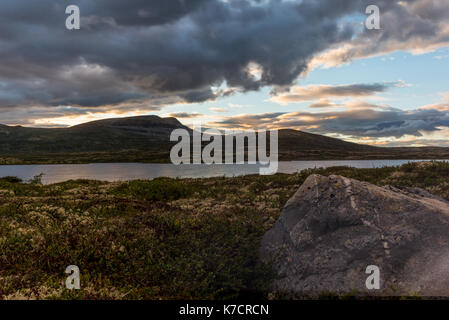 Les nuages reflétant sur un lac norvégien au coucher du soleil dans le Parc National de Rondane en Norvège Banque D'Images