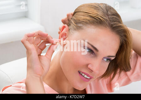 Close-up of young woman cleaning coton-tige avec de l'oreille Banque D'Images