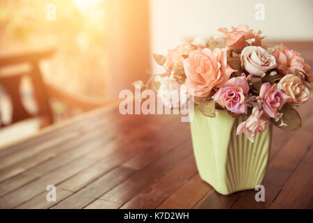 Belle rose pot de fleurs sur la table de bois nature décoration maison avec sun light vintage la nuance de couleur. Banque D'Images