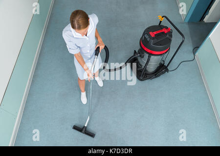 High Angle View of Female Worker Cleaning Aspirateur Banque D'Images