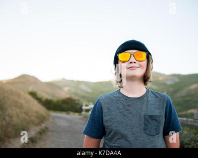 Garçon dans les lunettes de l'article sur terrain contre montagne Banque D'Images