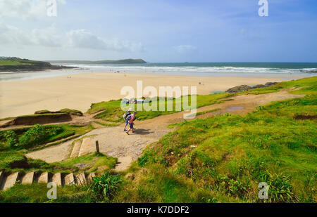 Deux randonneurs sur le chemin south west Cornwall à Polzeath surf plage à marée basse .Polzeath est une petite station balnéaire à Cornwall, England, UK Banque D'Images