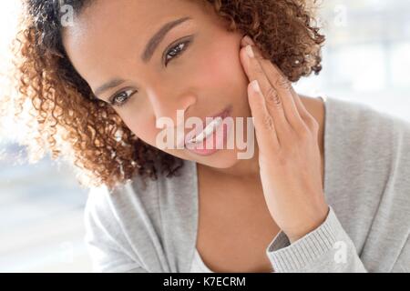 Portrait of mid adult woman touching face. Banque D'Images