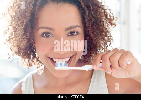 Portrait of mid adult woman se brosser les dents. Banque D'Images