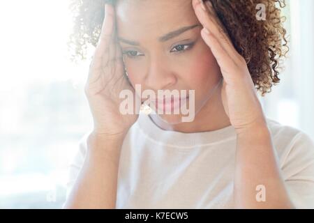 Mid adult woman touching her head. Banque D'Images