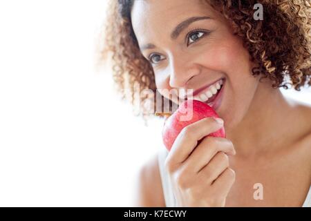 Mid adult woman eating apple. Banque D'Images