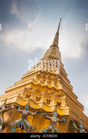 Magnifique Chedi doré orné avec des gardiens mythiques de démon autour de la base. Wat Phra Kaew (Temple du Bouddha d'Émeraude), le Grand Palais, Thaïlande Banque D'Images