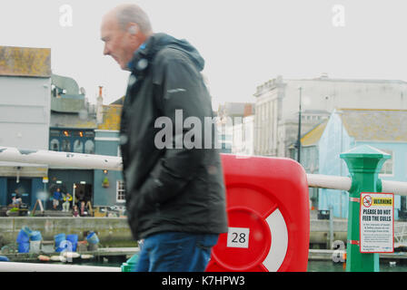 Weymouth, Royaume-Uni. 16 septembre 2017 - un homme lutte contre les douches sur le vieux port de Weymouth crédit : Stuart fretwell/Alamy live news Banque D'Images