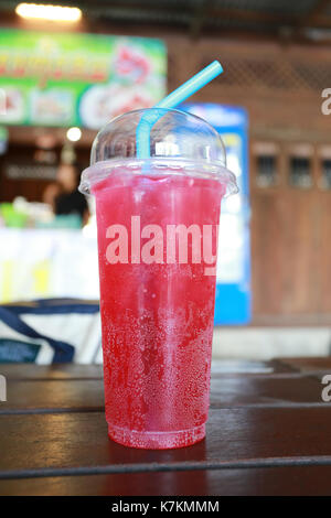 Boisson soda rouge en verre sur la table des aliments. Banque D'Images