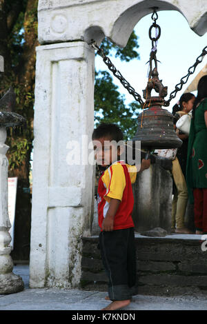 Petit garçon-pèlerin hindou sacré lors d'une sonnerie au temple de la Déesse Durga. Himalaya, Pokhara, Népal. Banque D'Images