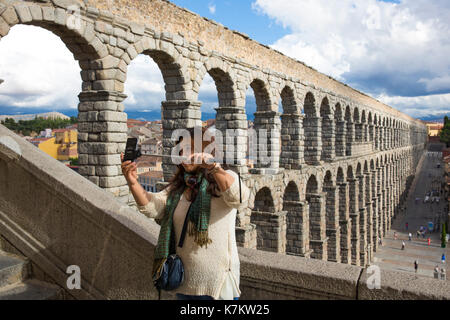Prendre des photographies touristiques selfies sur smartphone Avec bâton à selfies spectaculaire célèbre aqueduc romain, Segovia, Espagne Banque D'Images