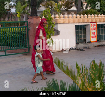 Les pèlerins dans le temple - une femme dans un sari rouge et un petit garçon. Casablanca Mandir, le sud-ouest de banlieue de New Delhi, Inde. Banque D'Images