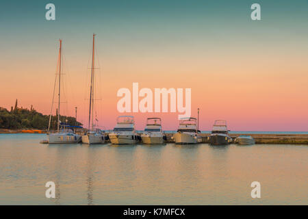 Yachts et bateaux à voile parking dans petit port sur Crveni Otok près de Rovinj, Croatie en beau matin lever du soleil Banque D'Images