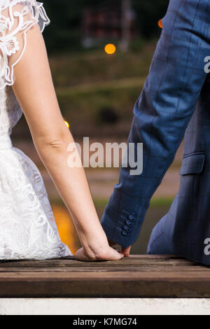 Bride and Groom holding hands par le lac de nuit Banque D'Images
