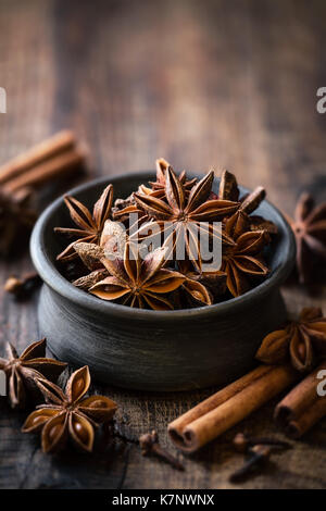 Étoile d'anis dans un bol noir avec des bâtons de cannelle et de girofle. cuisson saisonnière hiver concept avec copie espace pour votre texte Banque D'Images