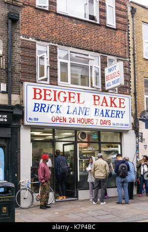 Les personnes mangeant dans la rue Beigel shop à Brick Lane. Banque D'Images