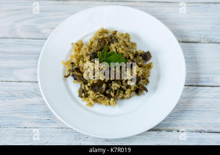 Le risotto. Garnir le plat. Riz aux champignons. Plat sur une plaque blanche. Banque D'Images