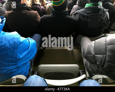 Un seul conducteur reste parmi une foule de supporters dans un stade indiquant un ventilateur est absent dehors sur le jeu ou métaphore de FOMO Banque D'Images