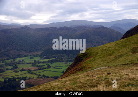 Un couple d'fellwalkers en faisant une pause sur hause gate sur la route à la Wainwright catbells donnant sur la vallée de borrowdale dans le lake district. Banque D'Images