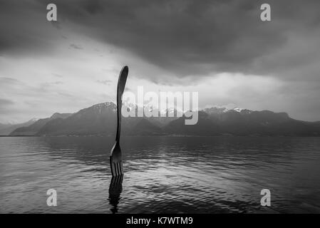Vevey, Suisse - 25 mai 2016 : fourche en acier géant dans l'eau du lac de Genève par temps nuageux, Vevey, Suisse. la photographie noir et blanc. Banque D'Images