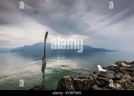 Vevey, Suisse - 25 mai 2016 : fourche en acier géant dans l'eau du lac de Genève par temps nuageux, vevey, suisse.La fourche est allé jusqu'en 1995 pour marquer le Banque D'Images