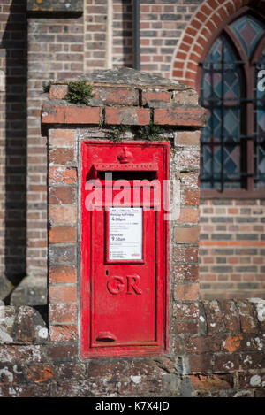 Boite aux lettres rouge en mur du bâtiment, West Sussex, Angleterre Banque D'Images