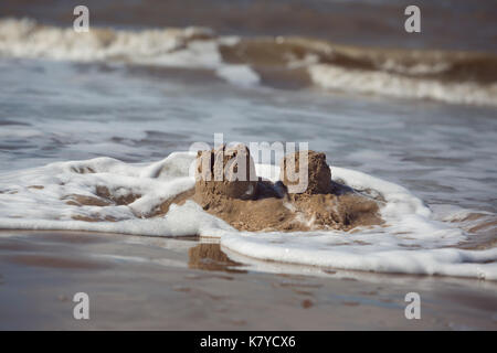 Vagues de la mer d'Irlande, de laver des châteaux à Formby, Angleterre Banque D'Images