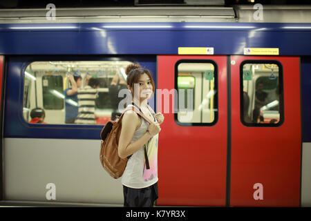 Le train d'attente fille plate-forme MTR prêt à aller, commencer son voyage à hong kong Banque D'Images