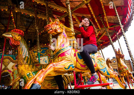 Pays de Galles Aberystwyth uk, dimanche 17 septembre 2017 une jeune femme bénéficiant d'un trajet sur l'noyce & sons célèbre 'golden gallopers ornés' fairground attraction carrousel pendant un week-end d'événements pour célébrer 95 ans de la great western sur la vallée de chemin de fer à voie étroite de rheidol à Aberystwyth Photo © Keith morris / alamy live news Banque D'Images