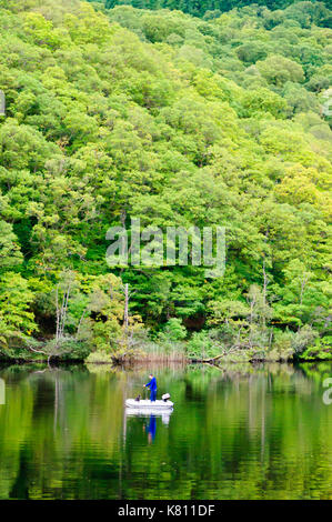 Loch Ard, Ecosse, Royaume-Uni. 17 Septembre, 2017. Météo France : Un homme d'un petit bateau de pêche avec son chien, la journée calme offre des réflexions sur la surface de l'eau. Loch Ard est un organe de l'eau douce dans le parc national du Loch Lomond et des Trossachs du district de Stirling en Écosse. Credit : Skully/Alamy Live News Banque D'Images