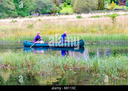 Loch Ard, Ecosse, Royaume-Uni. 17 Septembre, 2017. Météo France : deux personnes paddling un canot ouvert, la journée calme offre des réflexions sur la surface de l'eau. Loch Ard est un organe de l'eau douce dans le parc national du Loch Lomond et des Trossachs du district de Stirling en Écosse. Credit : Skully/Alamy Live News Banque D'Images