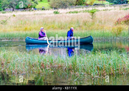 Loch Ard, Ecosse, Royaume-Uni. 17 Septembre, 2017. Météo France : deux personnes paddling un canot ouvert, la journée calme offre des réflexions sur la surface de l'eau. Loch Ard est un organe de l'eau douce dans le parc national du Loch Lomond et des Trossachs du district de Stirling en Écosse. Credit : Skully/Alamy Live News Banque D'Images