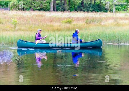 Loch Ard, Ecosse, Royaume-Uni. 17 Septembre, 2017. Météo France : deux personnes paddling un canot ouvert, la journée calme offre des réflexions sur la surface de l'eau. Loch Ard est un organe de l'eau douce dans le parc national du Loch Lomond et des Trossachs du district de Stirling en Écosse. Credit : Skully/Alamy Live News Banque D'Images