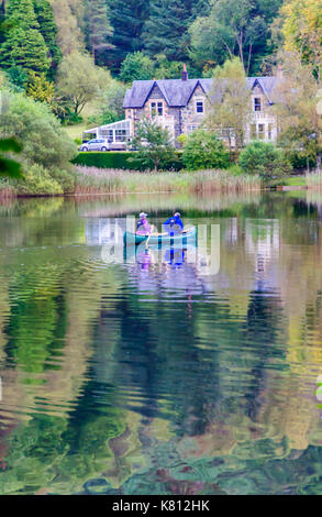 Loch Ard, Ecosse, Royaume-Uni. 17 Septembre, 2017. Météo France : deux personnes paddling un canot ouvert, la journée calme offre des réflexions sur la surface de l'eau. Loch Ard est un organe de l'eau douce dans le parc national du Loch Lomond et des Trossachs du district de Stirling en Écosse. Credit : Skully/Alamy Live News Banque D'Images