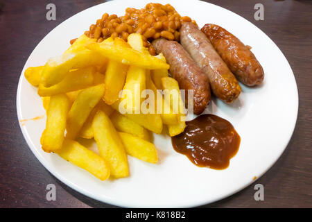 Un repas traditionnel café bon marché, saucisses, chips et des haricots à la sauce brune. Banque D'Images