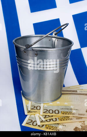 Drapeau grec avec un seau en métal de 200 billets en euros. Pour la crise financière grecque et le sauvetage, l'allégement de la dette grecque, la crise économique grecque, la récession grecque. Banque D'Images