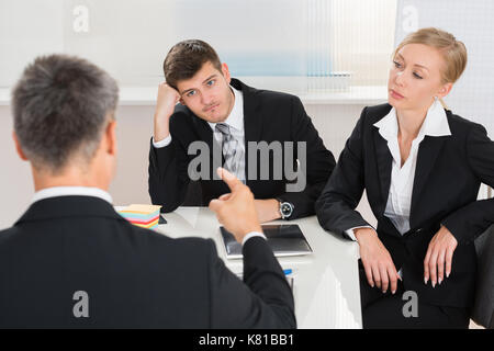 Groupe de trois businesspeople having argument au lieu de travail Banque D'Images