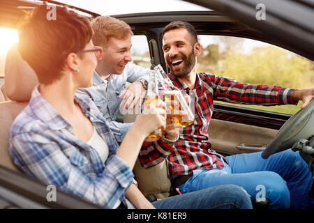 Group of smiling friends having fun dans la voiture on road trip Banque D'Images