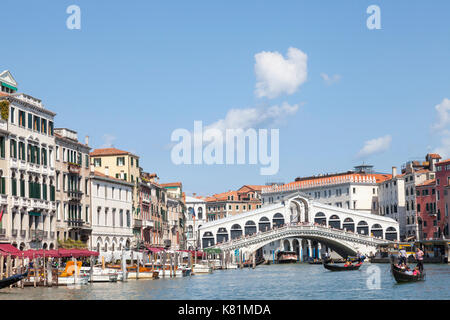 Jolie lumière sur le pont du Rialto et le Grand Canal, Venise, Vénétie, Italie après une tempête avec plusieurs gondoles avec des touristes dans l'avant-plan Banque D'Images