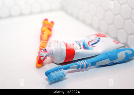 Brosses à dents et dentifrice sur un lavabo dans une salle de bains Banque D'Images