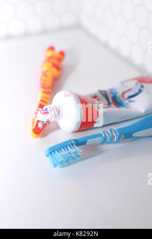 Brosses à dents et dentifrice sur un lavabo dans une salle de bains Banque D'Images