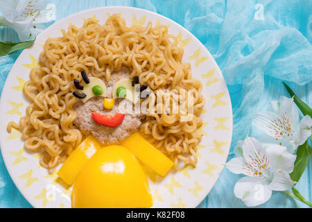Visage de nourriture drôle avec escalope, pâtes et légumes Banque D'Images