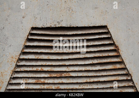 Grille de ventilation sur le vieux mur de métal peint en gris Banque D'Images