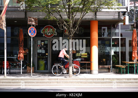 Mainz, Allemagne - le 21 août 2017 : un cycliste se déplace sur le trottoir à rock café chili pepper le 21 août 2017 à Mayence. Banque D'Images
