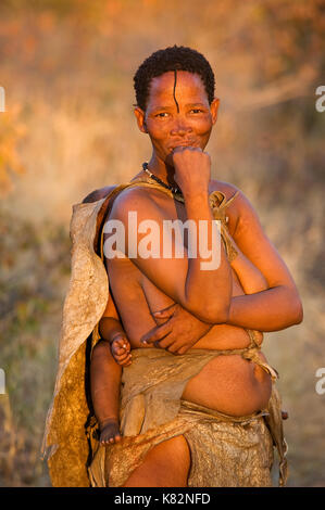 Ju/'hoansi bushmen San ou femme avec bébé sur le dos, Grashoek. Ils sont membres de plusieurs peuples chasseurs-cueilleurs d'Afrique australe Banque D'Images